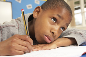 Unhappy Schoolboy Studying In Classroom